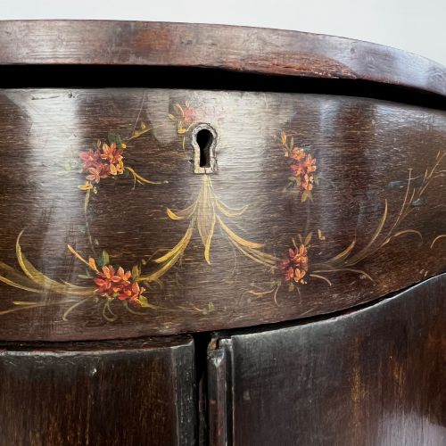 fig 4. A dark mahogany serpentine-front side cabinet with hand-painted floral swags and figurative door panel vignettes resting on slender square tapered legs.