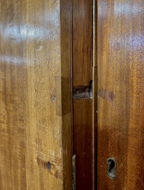 fig 8. A large George III mahogany breakfront linen press wardrobe featuring central panelled doors above drawers, flanked by side cupboards on bracket feet.