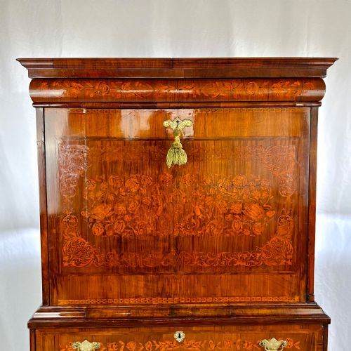 fig 1. A tall Georgian walnut escritoire bureau featuring floral marquetry inlay on the fall-front flap and lower drawers with brass drop handles.