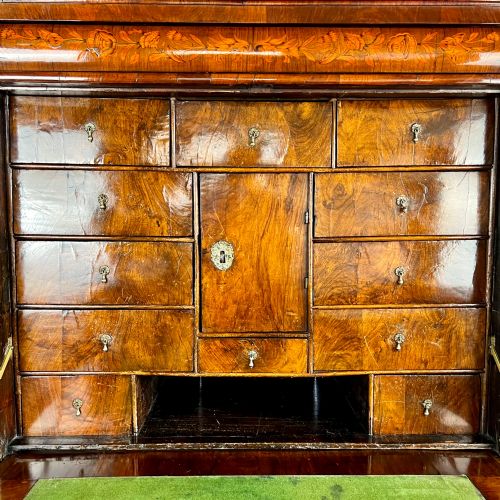 fig 6. A tall Georgian walnut escritoire bureau featuring floral marquetry inlay on the fall-front flap and lower drawers with brass drop handles.