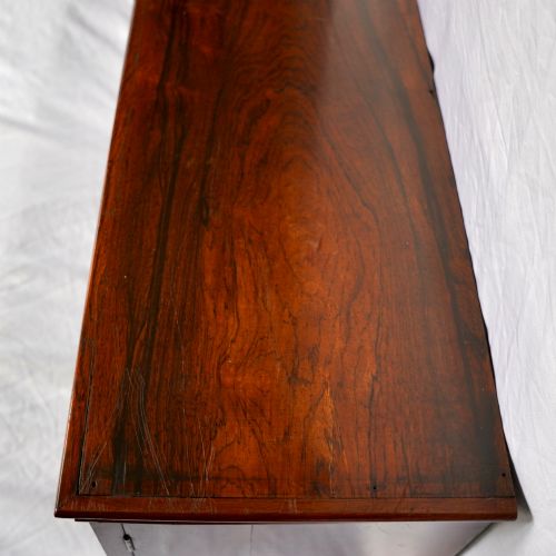 fig 6. A Regency period dark rosewood tabletop collectors cabinet featuring twin banks of small drawers flanking a central mirrored shelf unit with Gothic arched carving.