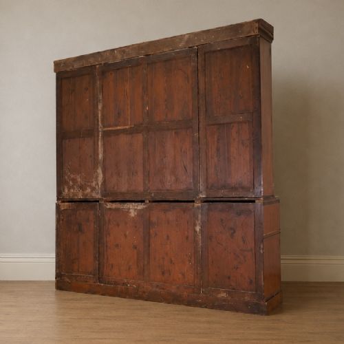 fig 1. A large George IV mahogany breakfront library bookcase featuring gothic astragal glazed upper doors above drawers and cupboard doors with geometric moulding.