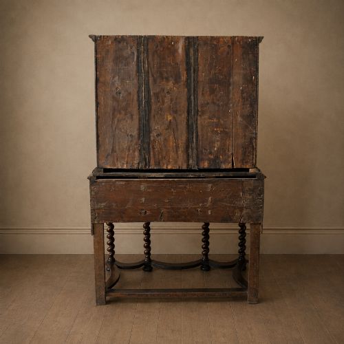 fig 5. A George I period figured walnut chest on stand featuring engraved brass escutcheons and six barley-twist legs.