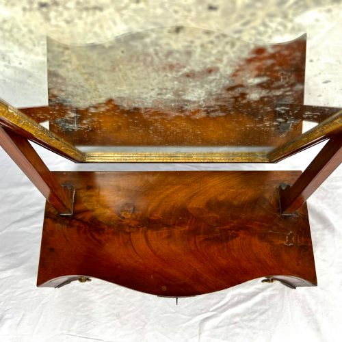 fig 2. A George III mahogany toilet dressing mirror featuring an upright rectangular swing mirror flanked by brass finials, mounted on a serpentine-front base with three small drawers.
