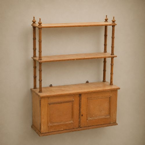 fig 1. A 19th-century wall-mounted pine rack featuring two open upper shelves supported by turned spindles with finials above an enclosed double-door cupboard.