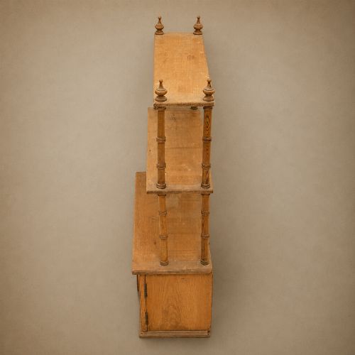 fig 5. A 19th-century wall-mounted pine rack featuring two open upper shelves supported by turned spindles with finials above an enclosed double-door cupboard.