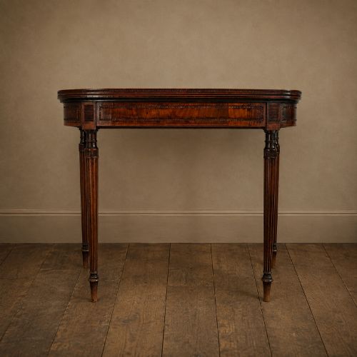 fig 2. An antique Regency rosewood fold-over card table featuring burr yew crossbanding, a rectangular top with rounded corners, and slender fluted tapered legs.