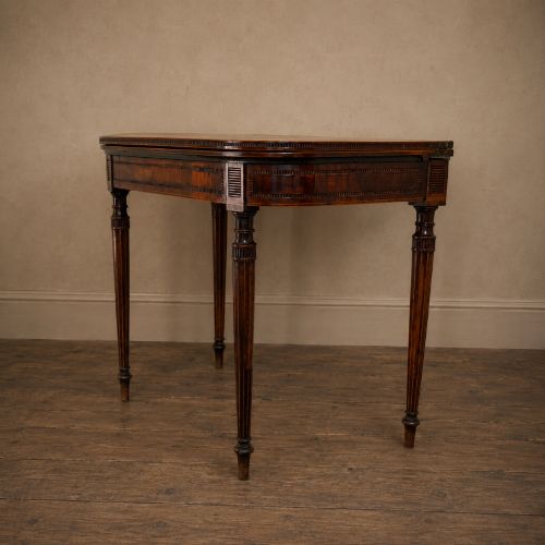 fig 8. An antique Regency rosewood fold-over card table featuring burr yew crossbanding, a rectangular top with rounded corners, and slender fluted tapered legs.