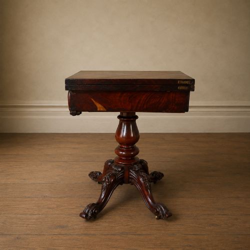 fig 9. A Victorian figured mahogany card table featuring a turnover top, carved frieze, turned pedestal, and scroll legs with castors.