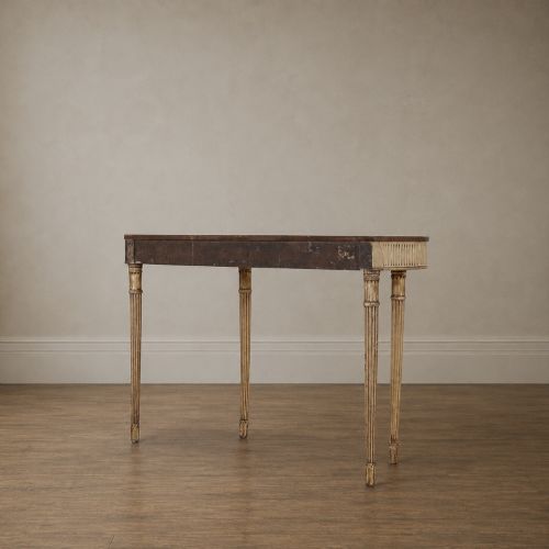 fig 2. A Georgian style painted cream and gilt console table featuring a dark wood top, fluted legs, and carved swag detailing.