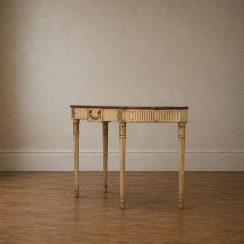 fig 3. A Georgian style painted cream and gilt console table featuring a dark wood top, fluted legs, and carved swag detailing.