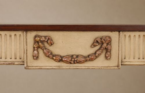 fig 5. A Georgian style painted cream and gilt console table featuring a dark wood top, fluted legs, and carved swag detailing.