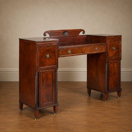 fig 1. A Regency figured mahogany pedestal sideboard with spiral-turned columns, brass drop handles, and a central carved splashback.