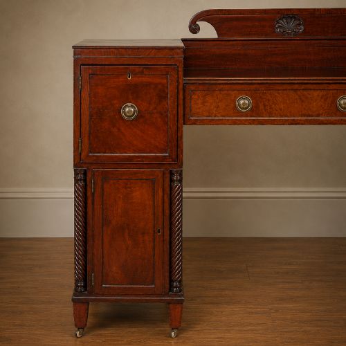 fig 3. A Regency figured mahogany pedestal sideboard with spiral-turned columns, brass drop handles, and a central carved splashback.