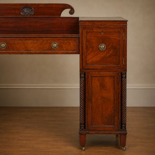 fig 4. A Regency figured mahogany pedestal sideboard with spiral-turned columns, brass drop handles, and a central carved splashback.