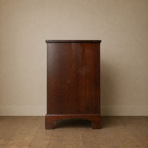 fig 3. A George II dark mahogany straight-front chest featuring four graduated long drawers with decorative brass swan-neck handles and bracket feet.