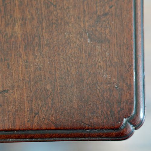fig 6. A George II dark mahogany straight-front chest featuring four graduated long drawers with decorative brass swan-neck handles and bracket feet.