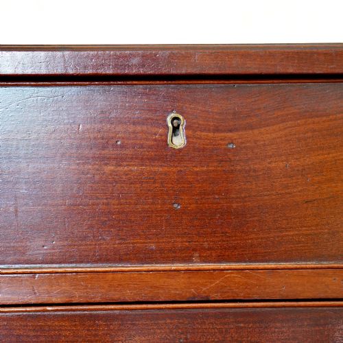fig 7. A George II dark mahogany straight-front chest featuring four graduated long drawers with decorative brass swan-neck handles and bracket feet.
