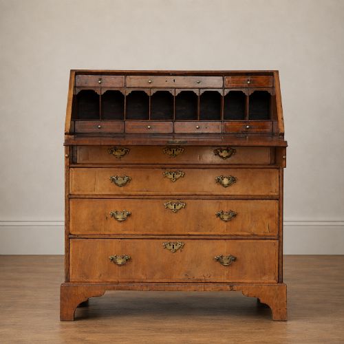 fig 1. An Early Georgian walnut bureau featuring a sloping drop-front writing lid, four graduated drawers with brass drop handles, and bracket feet.