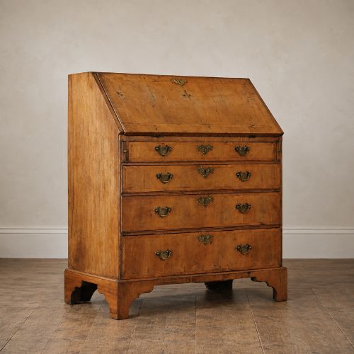 fig 2. An Early Georgian walnut bureau featuring a sloping drop-front writing lid, four graduated drawers with brass drop handles, and bracket feet.