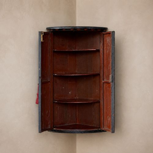 fig 1. A nineteenth-century bow-front corner cupboard crafted in dark black lacquer with gold hand-painted chinoiserie figures and architectural scenes.