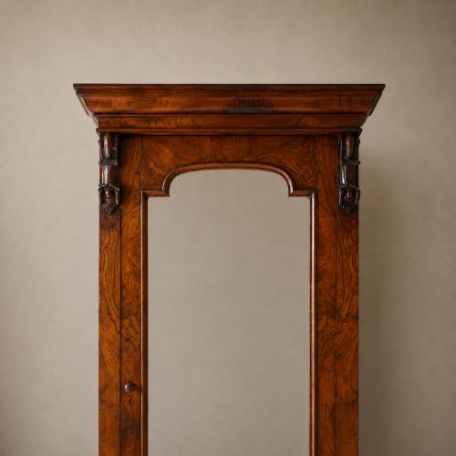 fig 7. A Victorian single-door wardrobe crafted from figured walnut wood, featuring a central arch-topped mirror panel, carved corbels, and a heavy moulded cornice.