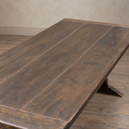 fig 8. An early twentieth-century dark oak refectory dining table featuring a plank top, pierced trestle end supports, and a central connecting stretcher.
