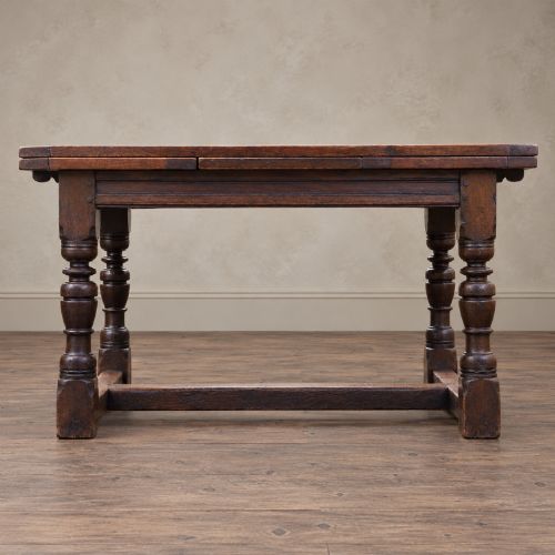 fig 1. A 17th-century solid oak extending dining table featuring turned legs, lower stretcher rails, and two draw-out end leaves.