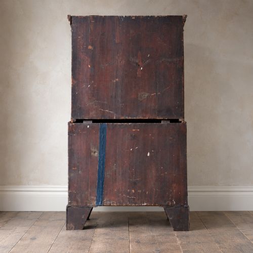 fig 3. An eighteenth-century Georgian figured mahogany chest on chest featuring a carved dentil cornice, brass swan-neck handles, a pull-out brushing slide, and bracket feet.
