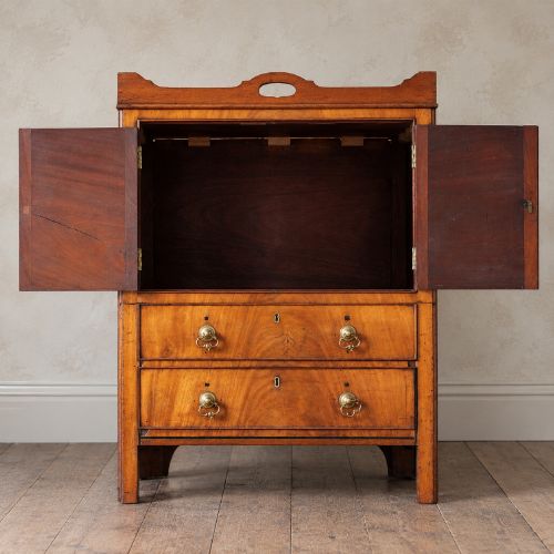 fig 1. A 19th-century mahogany tray top night commode featuring two cabinet doors with oval marquetry inlays above two drawers with brass handles.