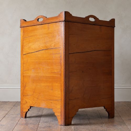 fig 4. A 19th-century mahogany tray top night commode featuring two cabinet doors with oval marquetry inlays above two drawers with brass handles.