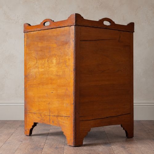fig 5. A 19th-century mahogany tray top night commode featuring two cabinet doors with oval marquetry inlays above two drawers with brass handles.