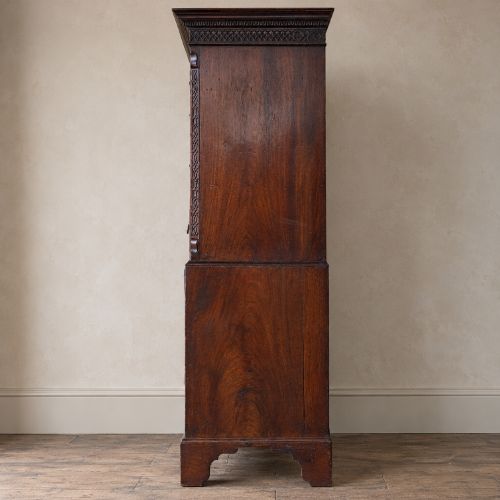 fig 3. A George III mahogany chest on chest featuring two short over six long graduated drawers, a brushing slide, blind fretwork frieze, brass swan-neck handles, and bracket feet.