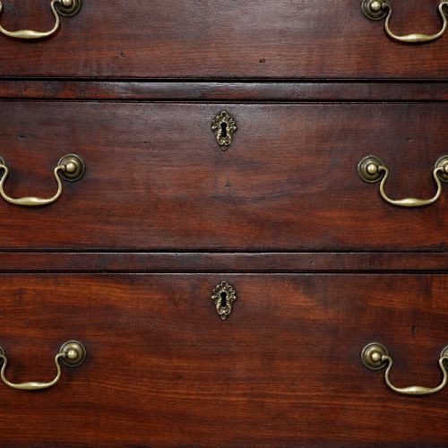 fig 7. A George III mahogany chest on chest featuring two short over six long graduated drawers, a brushing slide, blind fretwork frieze, brass swan-neck handles, and bracket feet.