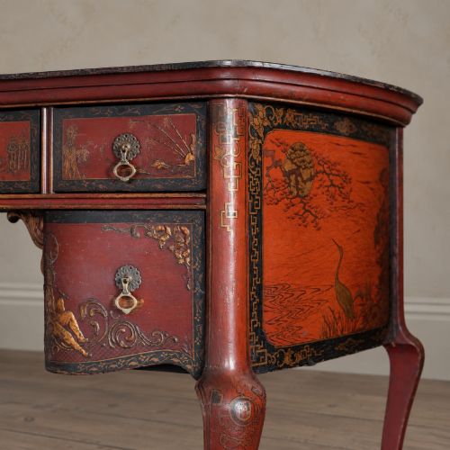 fig 1. A late nineteenth-century kidney-shaped red lacquered Chinoiserie dressing table featuring four drawers, hand-painted oriental scenes, and cabriole legs.