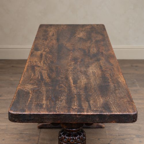 fig 1. A 17th-century oak and elm refectory dining table featuring a solid single-plank top over thick carved bulbous pedestal supports and a low central stretcher rail.