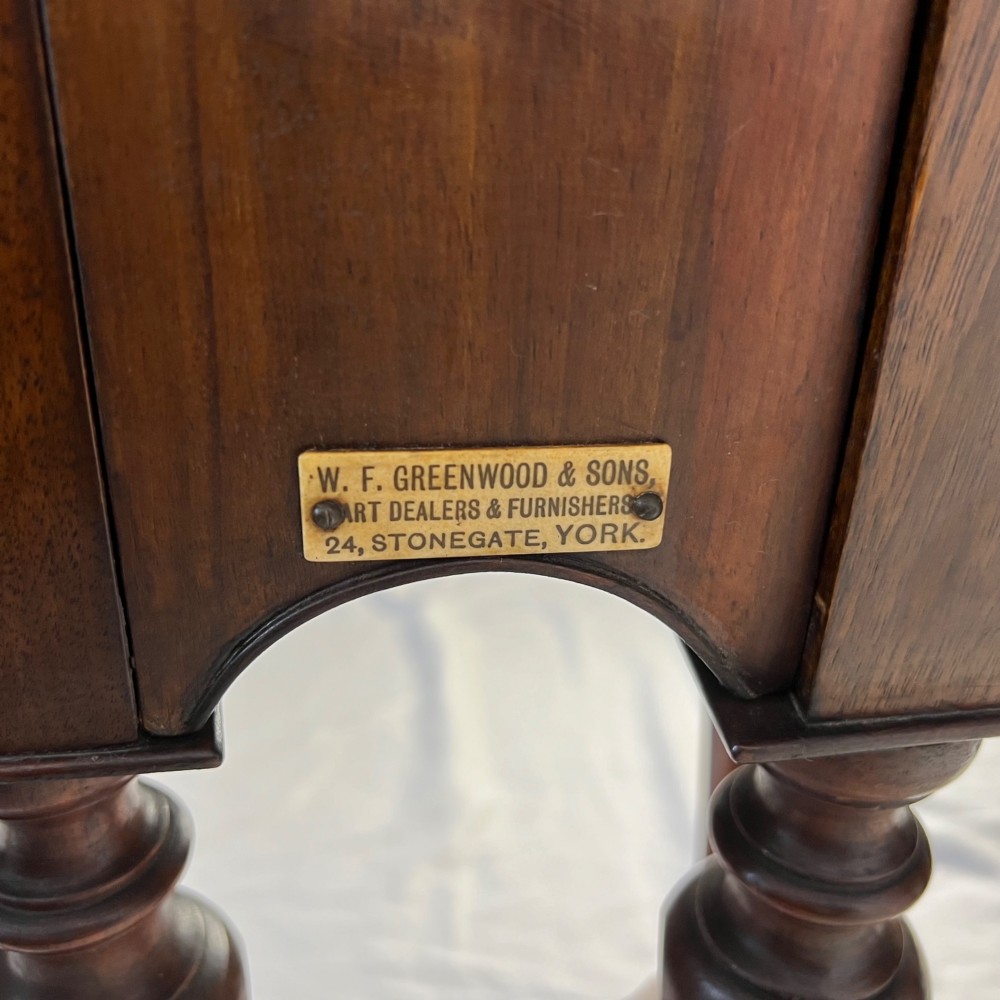 A Victorian figured walnut demi-lune card table featuring a scalloped apron, small frieze drawers, multiple turned legs, and a shaped stretcher base. View II