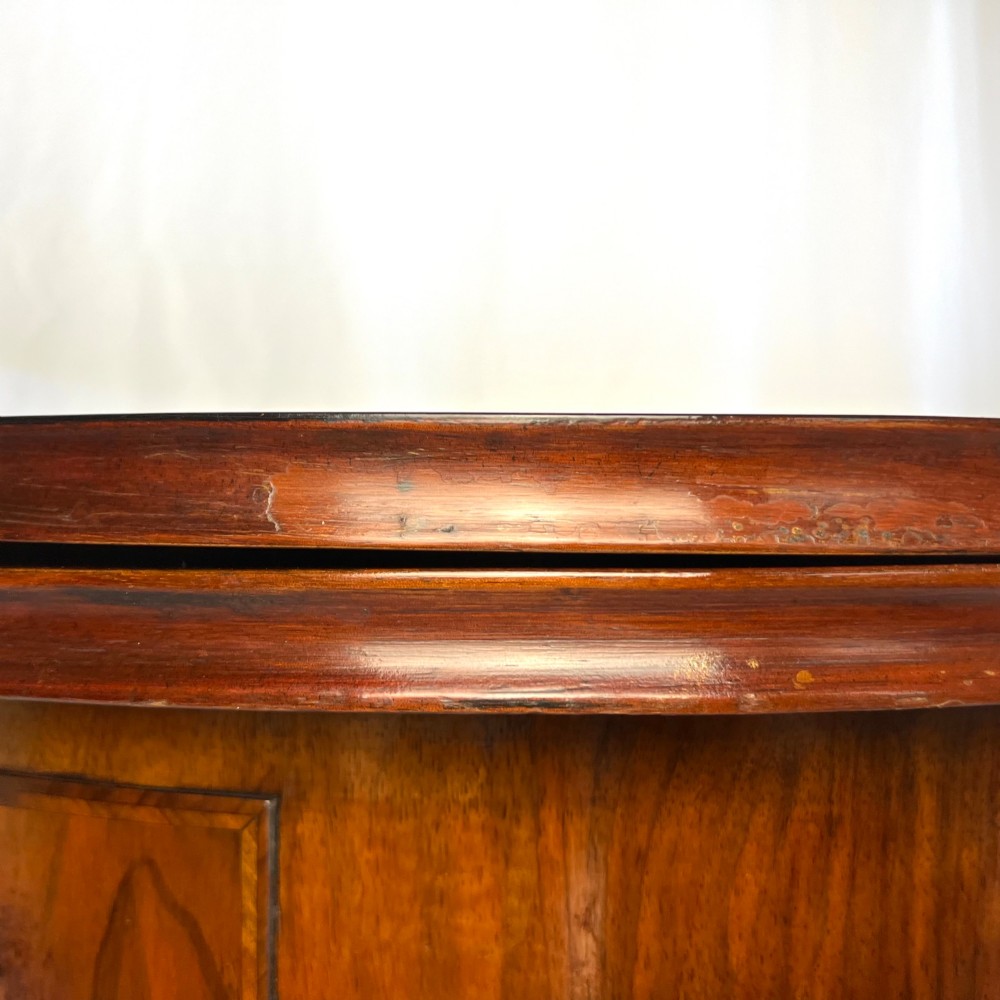 A Victorian figured walnut demi-lune card table featuring a scalloped apron, small frieze drawers, multiple turned legs, and a shaped stretcher base. View V