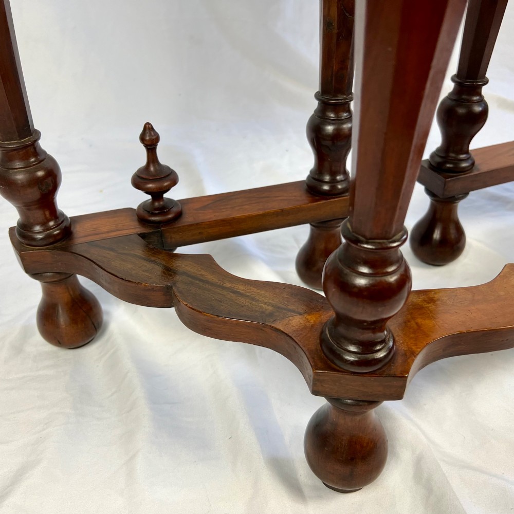 A Victorian figured walnut demi-lune card table featuring a scalloped apron, small frieze drawers, multiple turned legs, and a shaped stretcher base. View IX