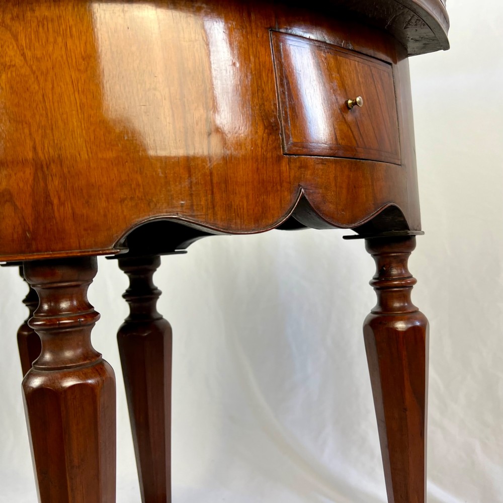 A Victorian figured walnut demi-lune card table featuring a scalloped apron, small frieze drawers, multiple turned legs, and a shaped stretcher base. View XII