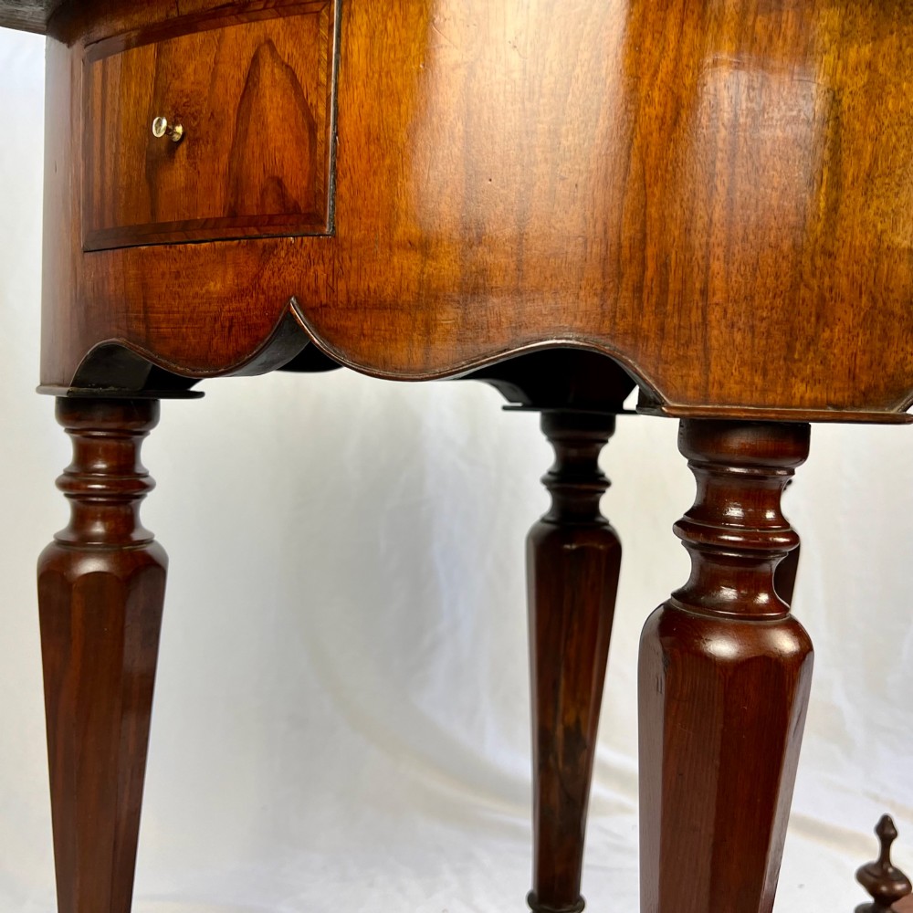 A Victorian figured walnut demi-lune card table featuring a scalloped apron, small frieze drawers, multiple turned legs, and a shaped stretcher base. View XIII
