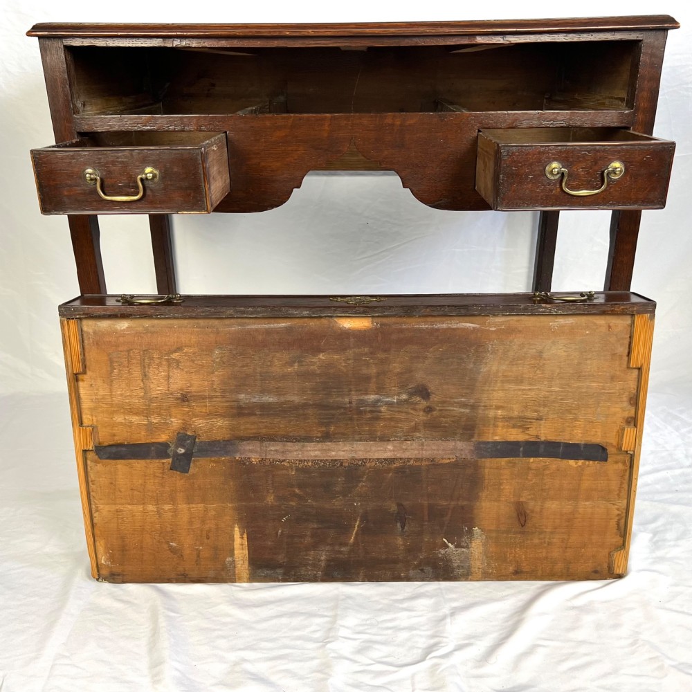 A George III dark oak lowboy table featuring three drawers with brass swan-neck handles, a shaped apron, and four square straight legs. View IX