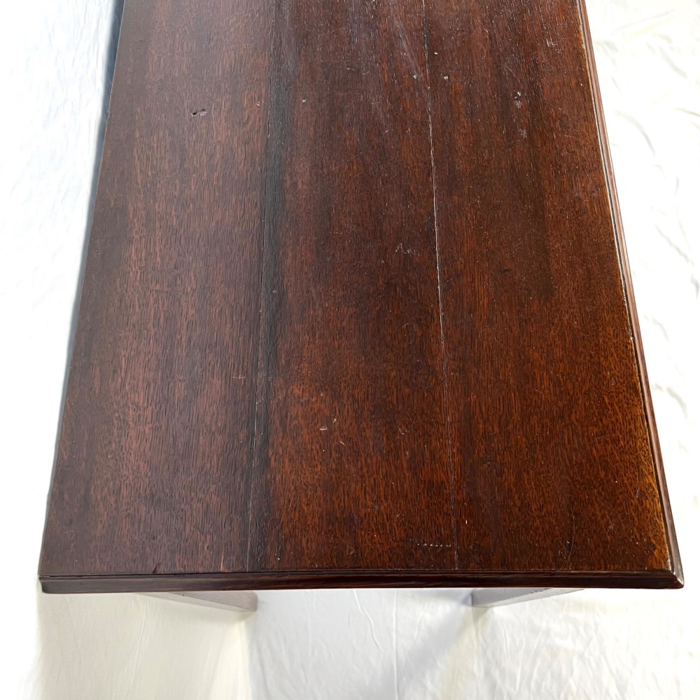 A George III dark oak lowboy table featuring three drawers with brass swan-neck handles, a shaped apron, and four square straight legs. View XI