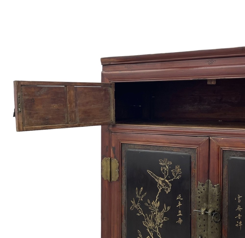 A late 19th-century Chinese red and black lacquer cabinet with double doors decorated with bird and botanical panels above two base drawers. View III