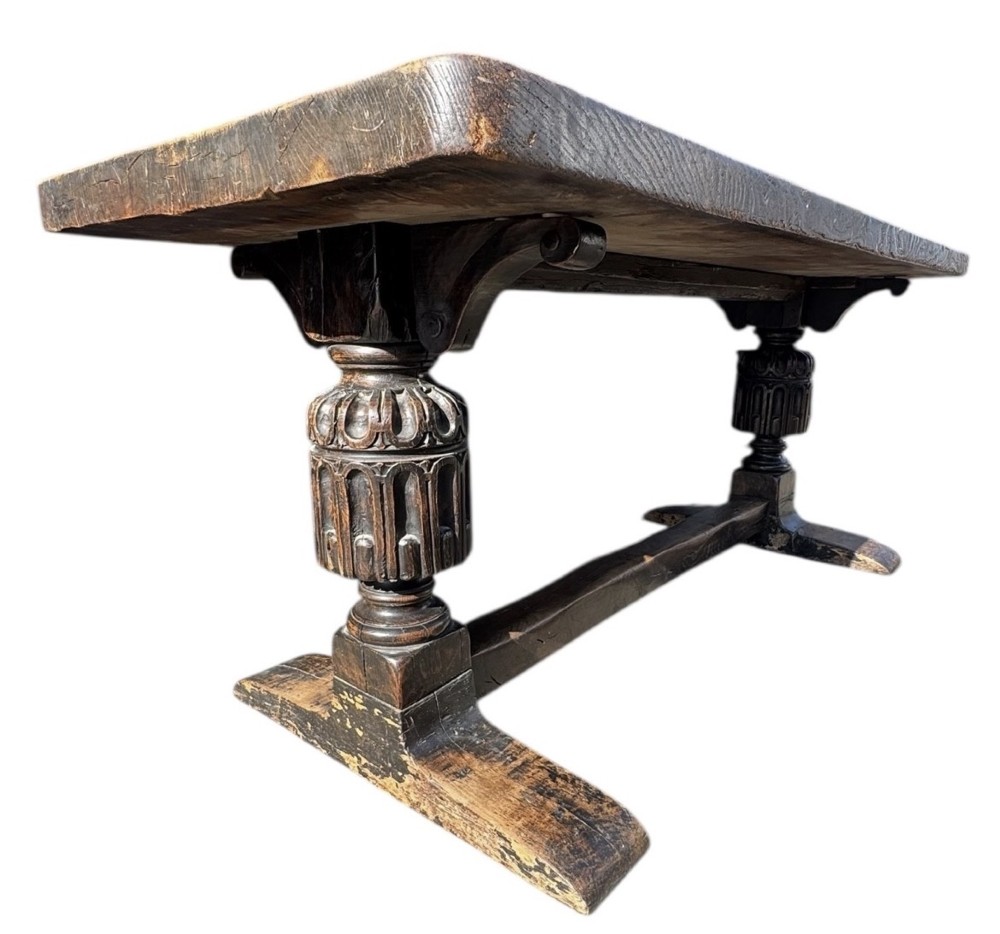 A 17th-century oak and elm refectory dining table featuring a solid single-plank top over thick carved bulbous pedestal supports and a low central stretcher rail. View II