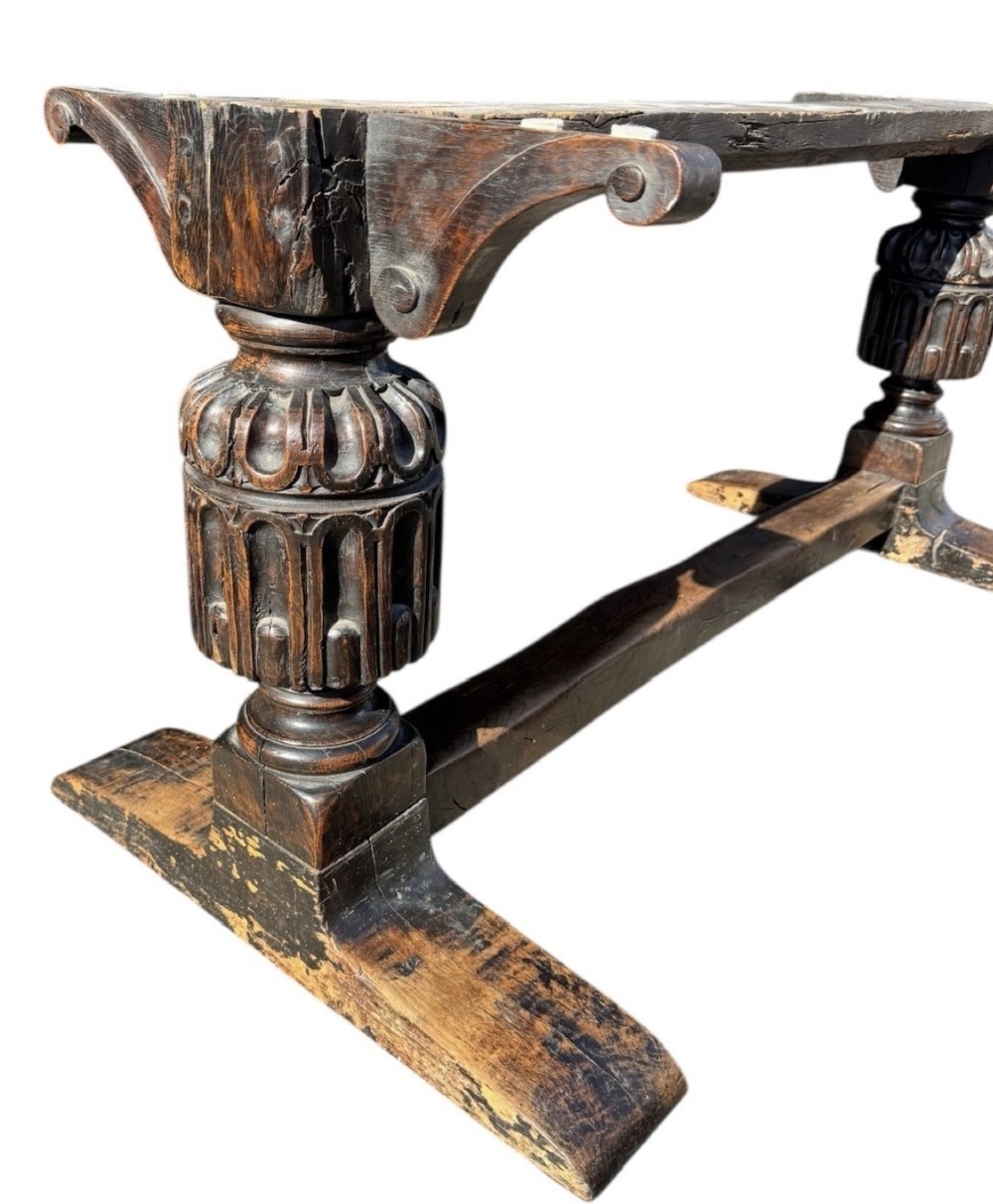 A 17th-century oak and elm refectory dining table featuring a solid single-plank top over thick carved bulbous pedestal supports and a low central stretcher rail. View X