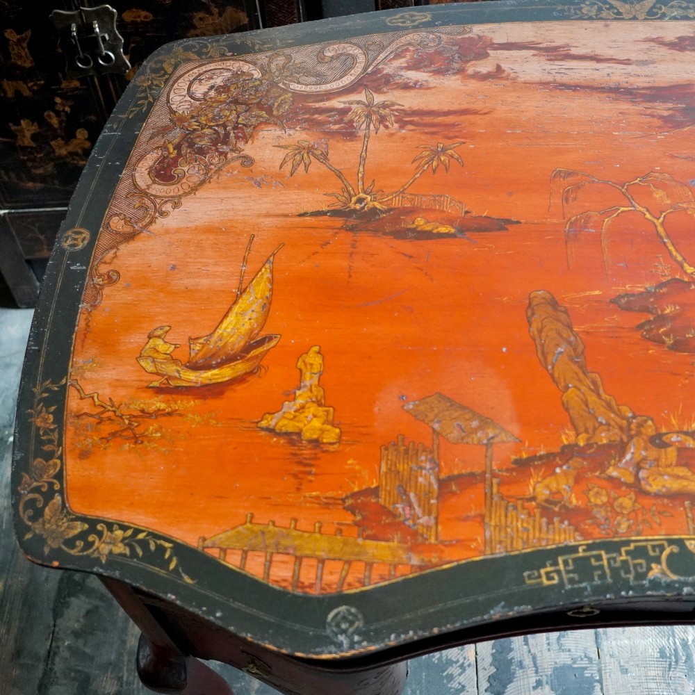 A late nineteenth-century kidney-shaped red lacquered Chinoiserie dressing table featuring four drawers, hand-painted oriental scenes, and cabriole legs. View V