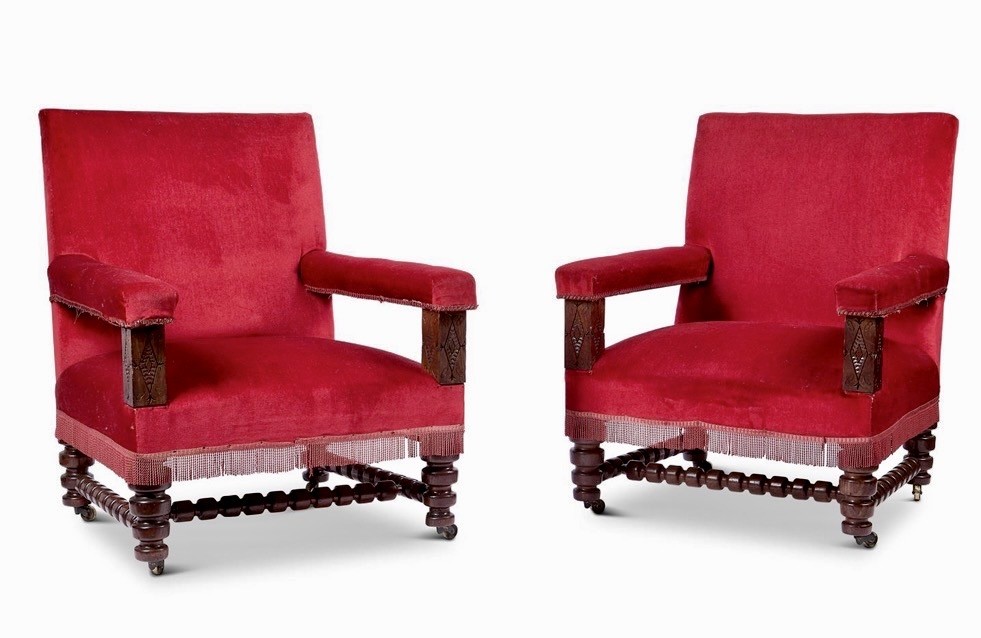 A pair of oversized Victorian armchairs upholstered in crimson red velvet with fringe trim, featuring carved oak arm supports and bobbin-turned legs. View II