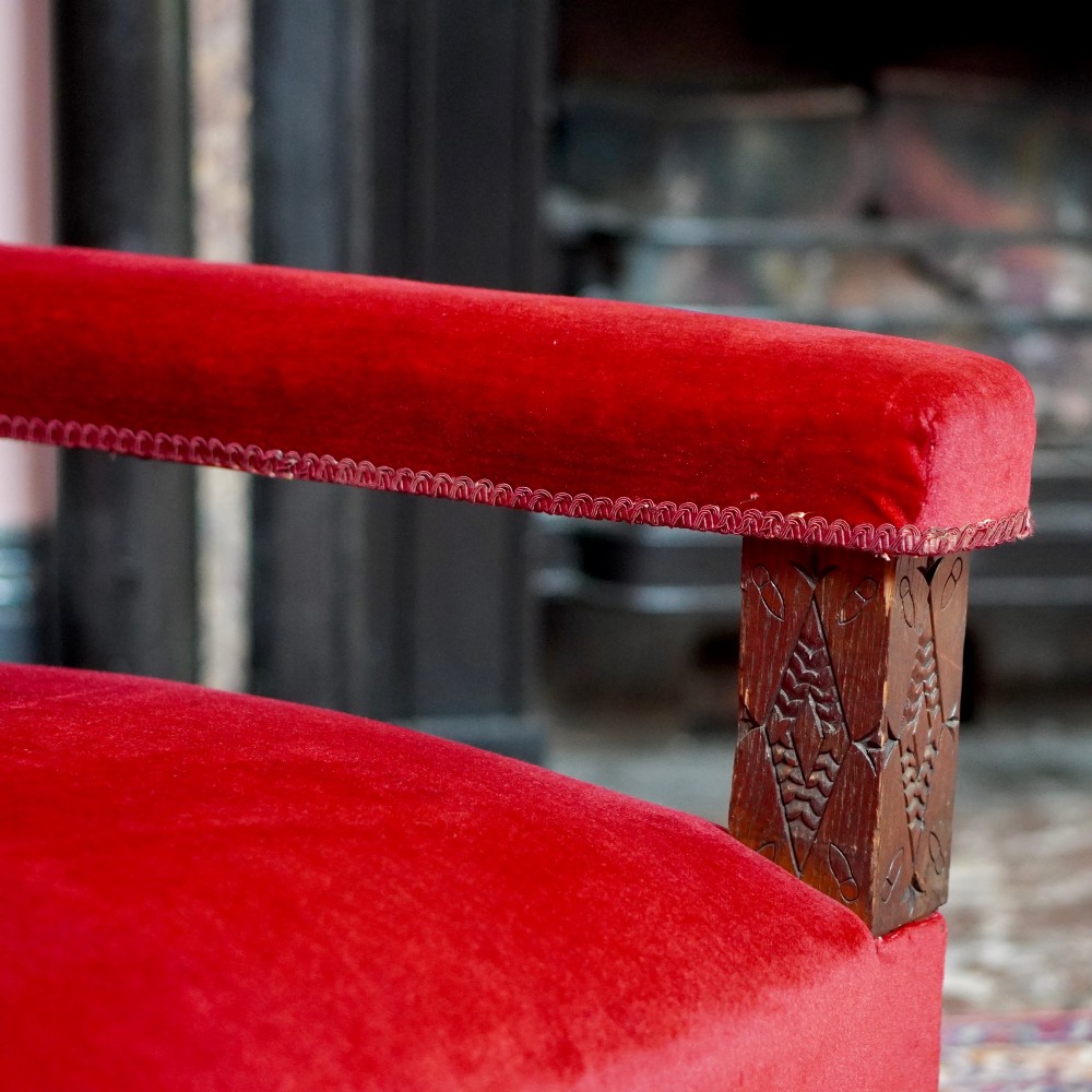 A pair of oversized Victorian armchairs upholstered in crimson red velvet with fringe trim, featuring carved oak arm supports and bobbin-turned legs. View VI