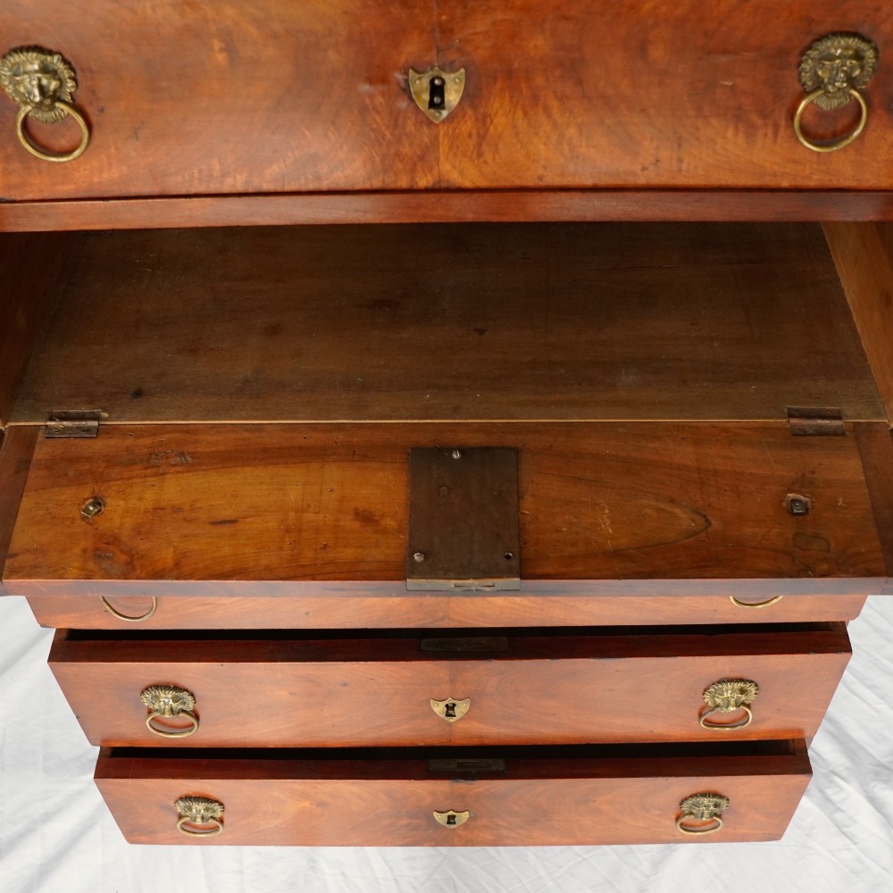 A 19th-century French Empire walnut secretaire cabinet featuring multiple drawers, brass lion-head ring handles, and fall-front writing compartments. View V